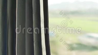 从火车的窗户看，阳光照在窗帘的左边，模糊的房子和国家后面的玻璃窗格的右边